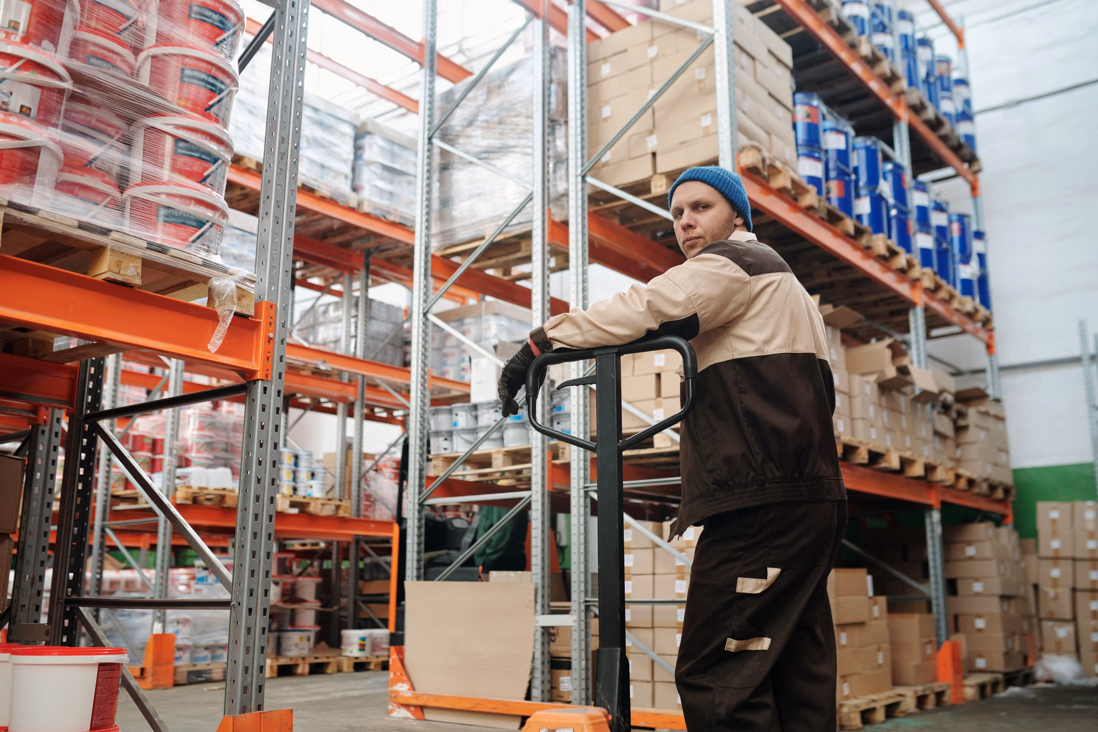 Warehouse worker moving cargo with a pallet jack